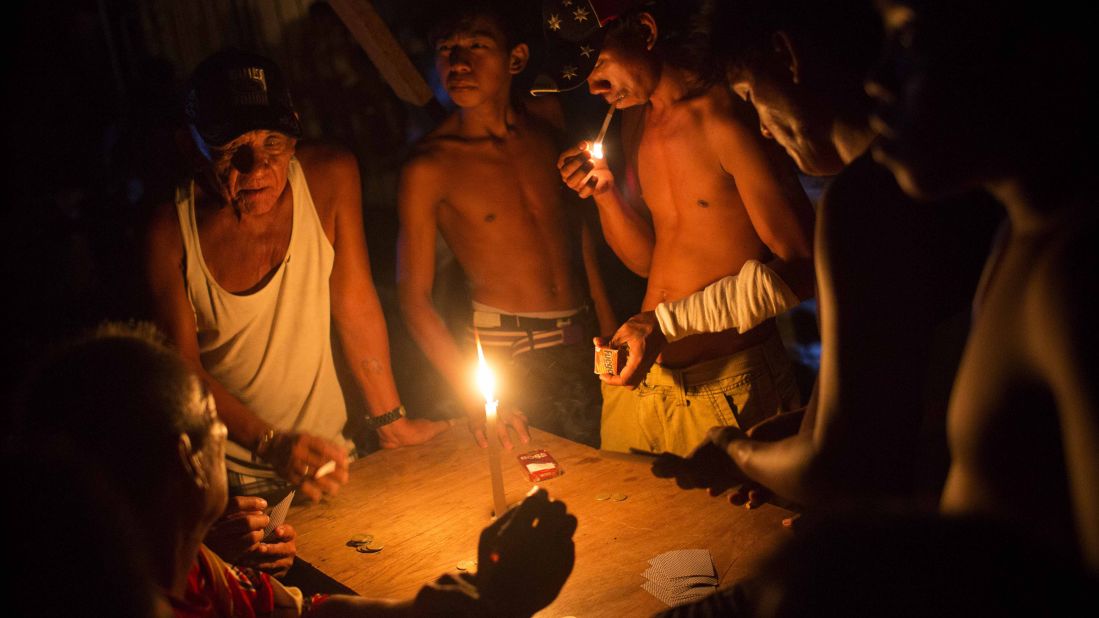 People play cards by candlelight Monday, November 18, in Tacloban.
