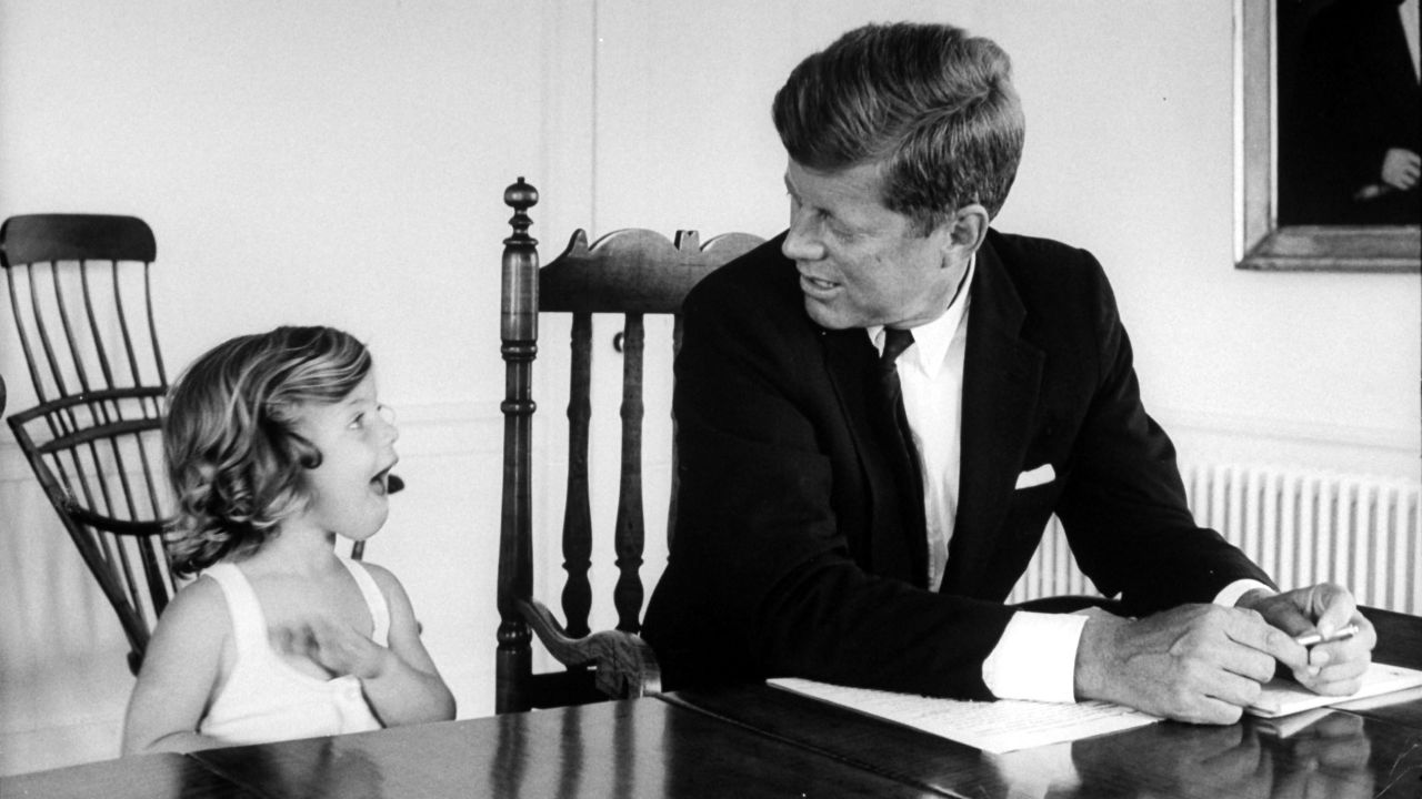 Sen. Kennedy takes a break from work to talk with Caroline at their Washington home in 1960.
