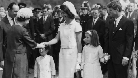 Caroline, alongside her mother and uncle Robert Kennedy, greet Queen Elizabeth II in London in 1965.