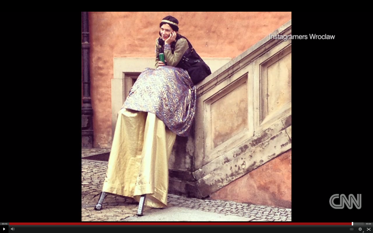 A smiling street performer takes a break and chats on her phone near Wroclaw's Market Square. Artists and dancers are a regular feature in and around central Wroclaw.