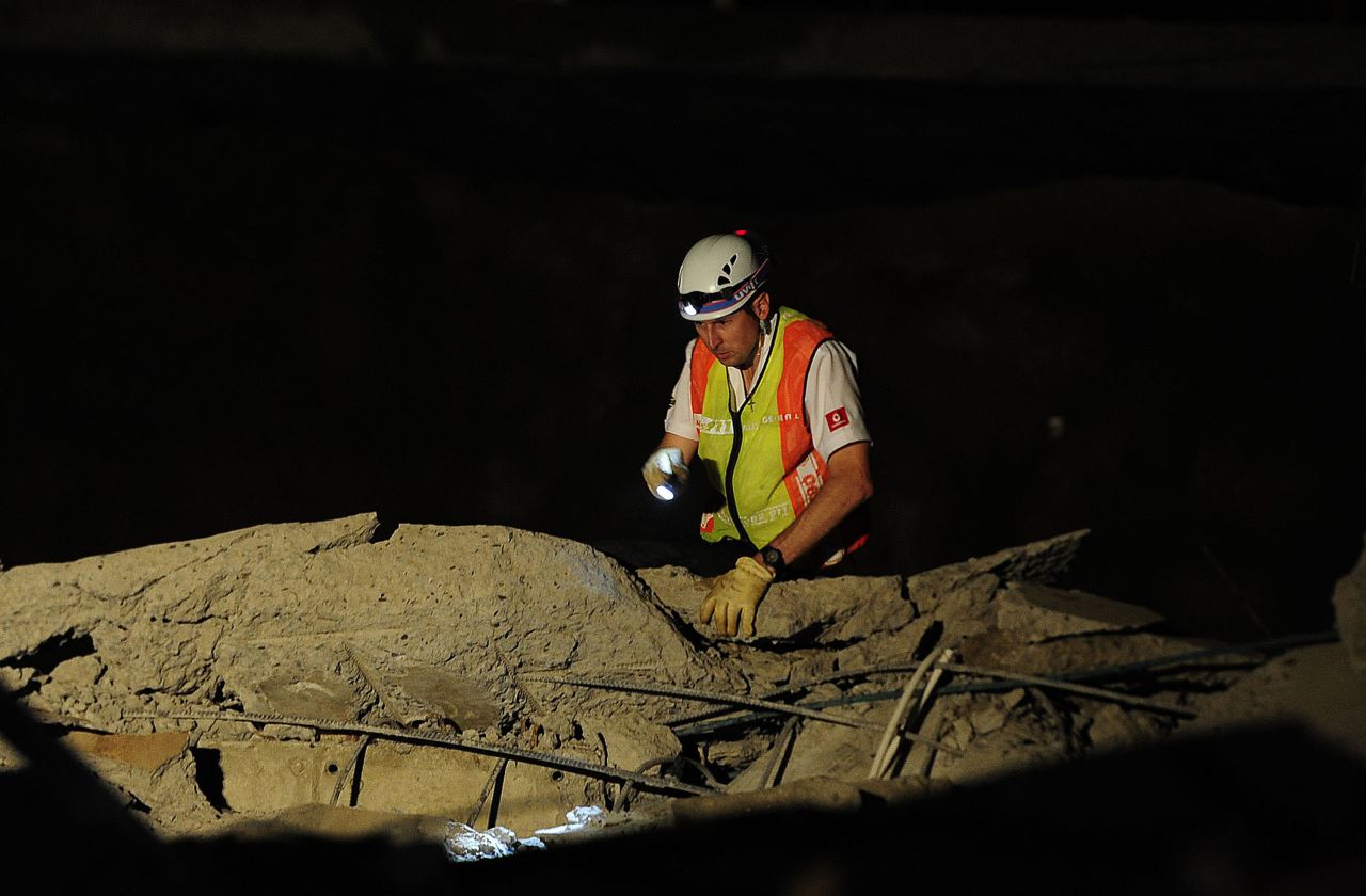 A paramedic looks for people trapped in the collapsed building. The South African Press Association reported that the building was a shopping mall under construction.