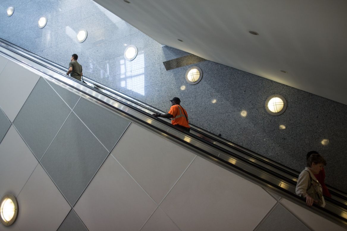 Personas suben las escaleras eléctricas cerca de Concourse E. 
