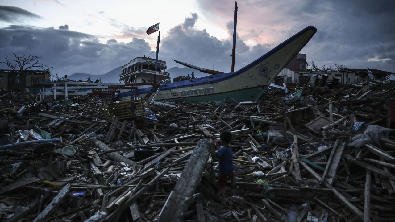 A boy climbs across debris in Tacloban on November 20.