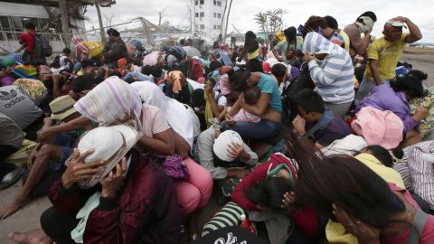 People at the airport in Tacloban react to a blast of wind from an aircraft on November 20.