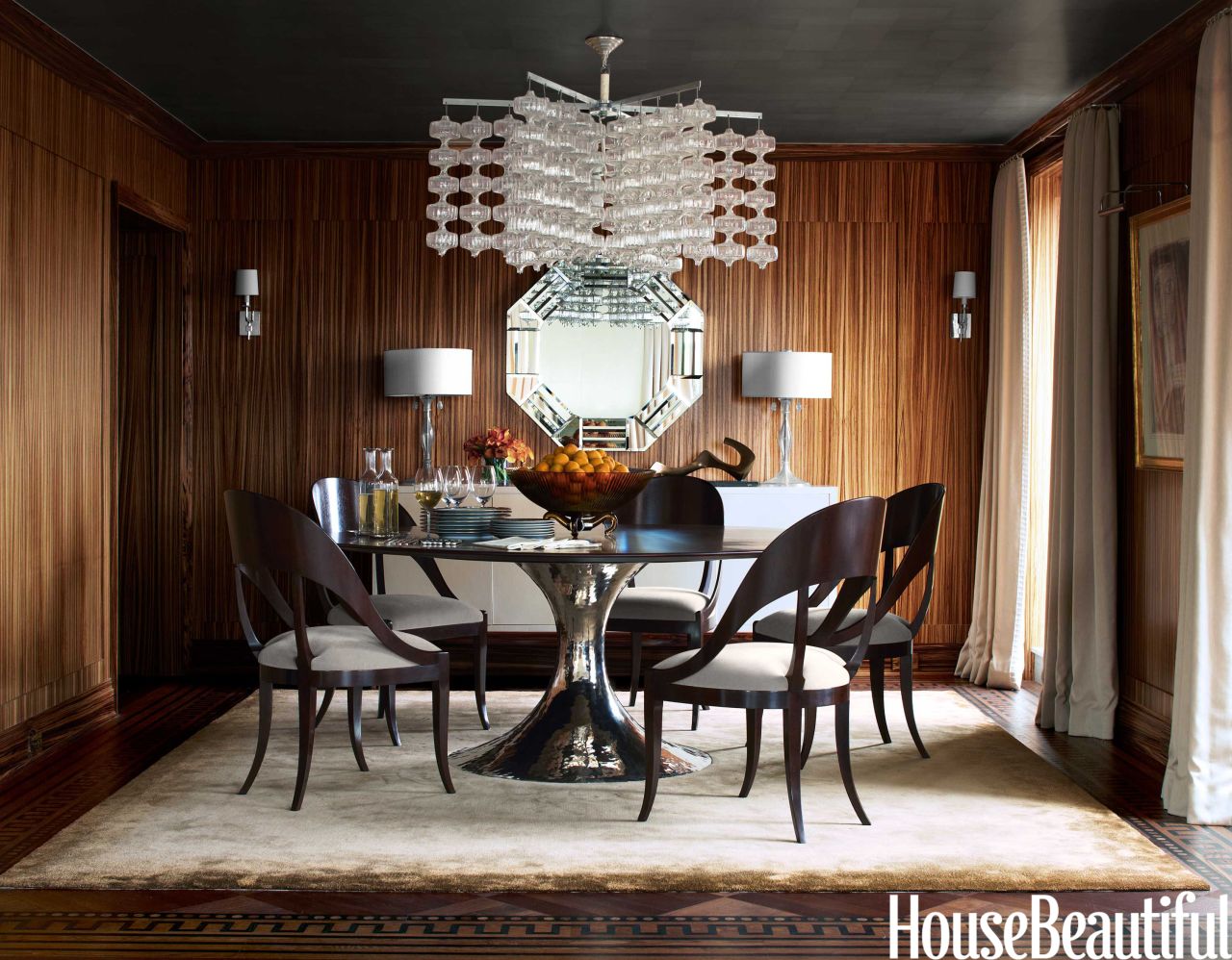 This dining room by Phoebe and Jim Howard, featured in the November 2013 issue of House Beautiful, sets modern-style furniture against moody wood walls.