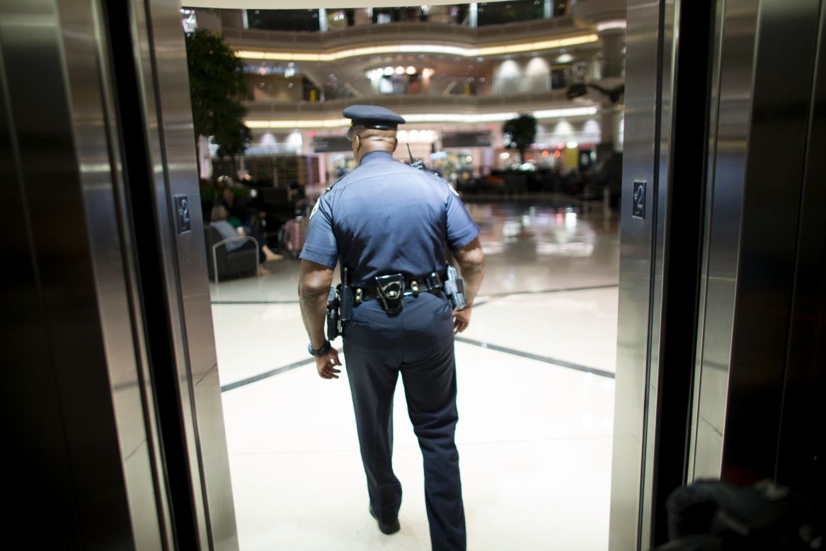 El sargento Vito Wallace sale del elevador y se dirige al atrio de la Terminal Nacional. 