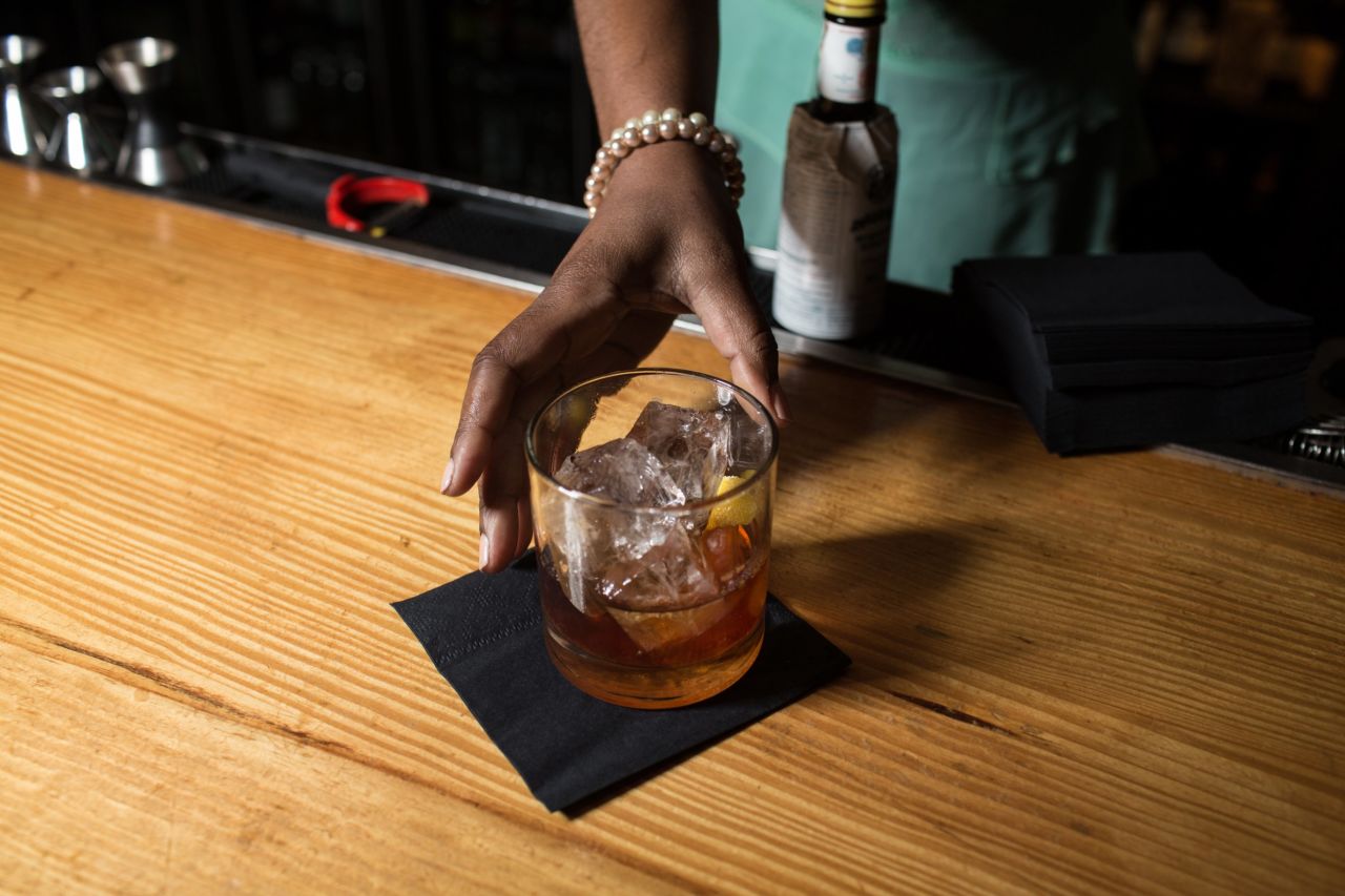 A One Flew South bartender serving an Old Fashioned.