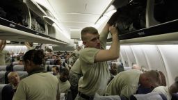  U.S. Army soldiers from the 2-82 Field Artillery, 3rd Brigade, 1st Cavalry Division, place their bags in the overhead bins as they wait for their plane to take off for the flight home to Fort Hood, Texas after being part of one of the last American combat units to exit from Iraq on December 16, 2011 in Kuwait City, Kuwait.