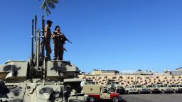 Members and vehicles of the Al-Qaaqa brigade from Zintan get ready to vacate the premises of their Tripoli quarter on November 21, 2013, as part of a government decision to remove militias from the capital and eventually integrate them into the security forces, after a weekend of deadly clashes between militiamen and residents. AFP PHOTO/MAHMUD TURKIA