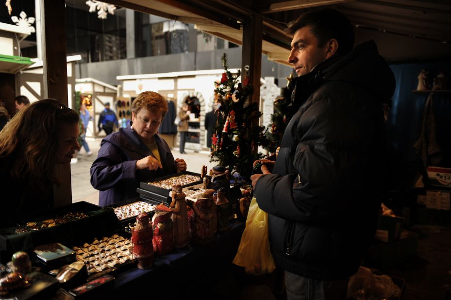 Andriy Shaptala waits on customers at one of his booths at the Denver Christkindl Market downtown. 