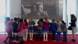 Children gather around a a multimedia display "John F. Kennedy His Life and Legacy" in the grand foyer at the John F. Kennedy Center for the Performing Arts in Washington, Friday, Nov. 22, 2013, on the 50th anniversary of President John F. Kennedy's death. (AP Photo/Carolyn Kaster)