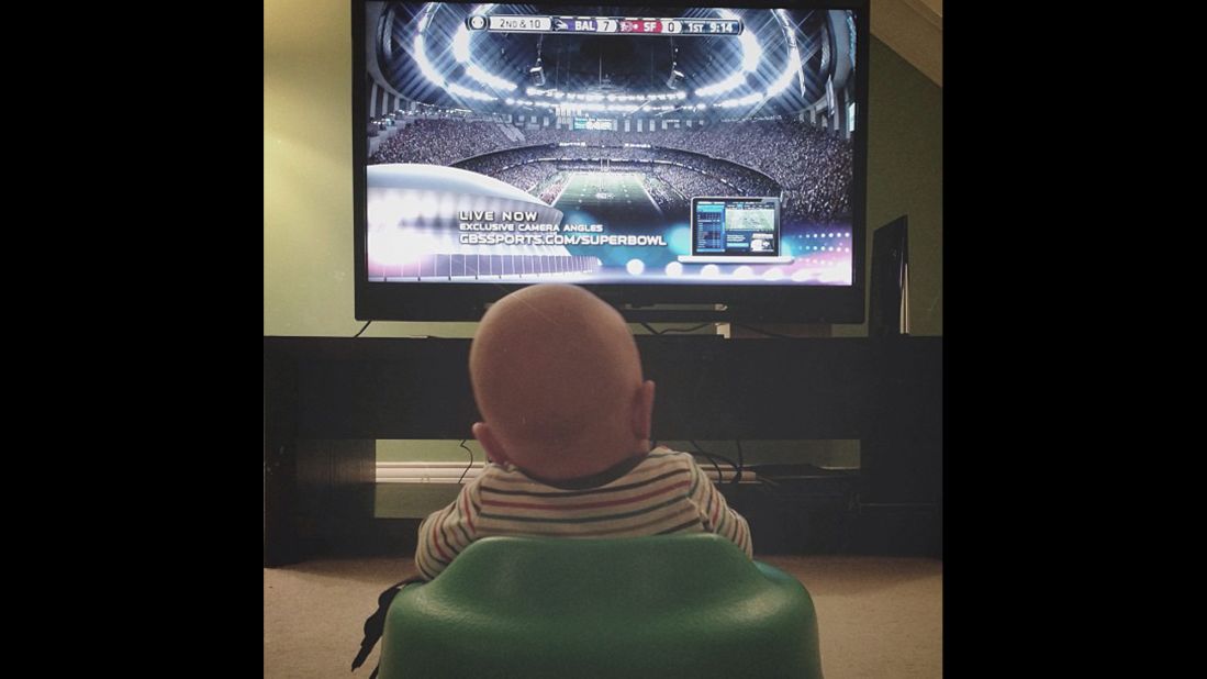 Ward watches football with his dad from the comfort of their living room. 