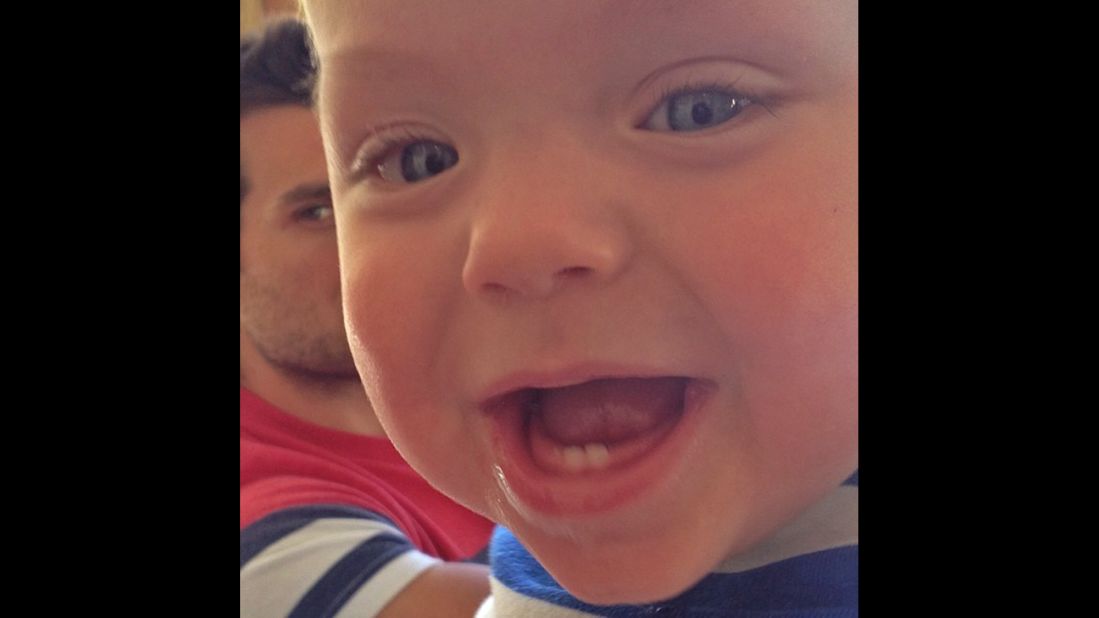 Ward gives a big gummy smile to the camera. His dad keeps a close eye on his son from behind. 