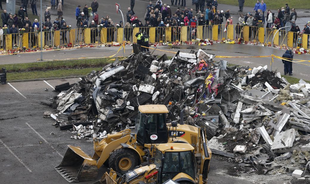 Debris piles up while people put flowers and light candles in front of the supermarket on November 23. The collapse was the Baltic state's deadliest accident since its independence from the Soviet Union in 1991, local media reported.