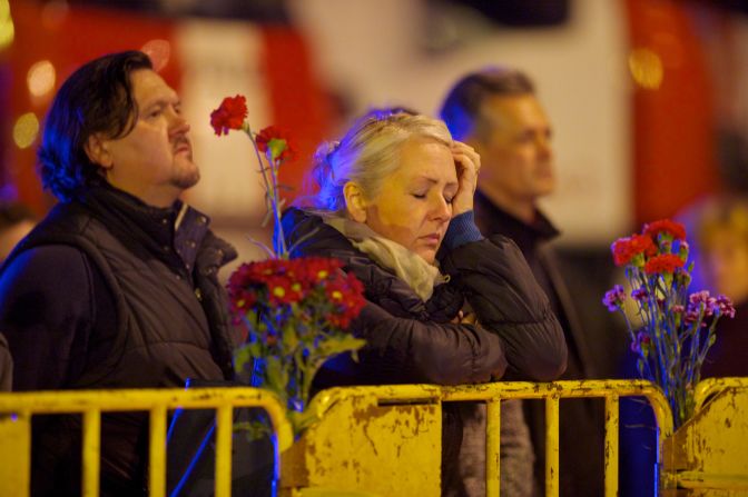 A woman waits for news near a barricade surrounding the supermarket on November 23. Local media reports firefighters are among the dead from the collapse.