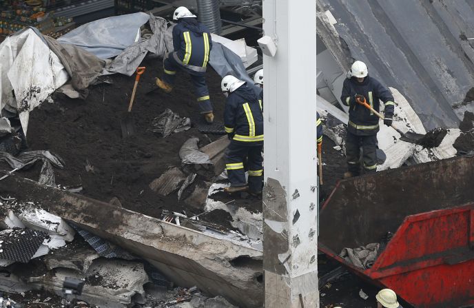 Rescue workers search debris on November 23. Search teams continue to comb the rubble for more bodies, Rescue Service spokeswoman Viktorija Sembele said.