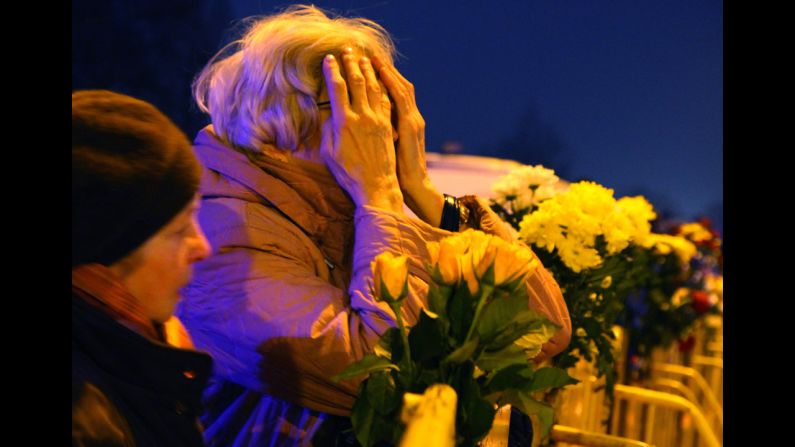 People leave flowers at the scene where the supermarket roof collapsed in Riga on Friday, November 22.