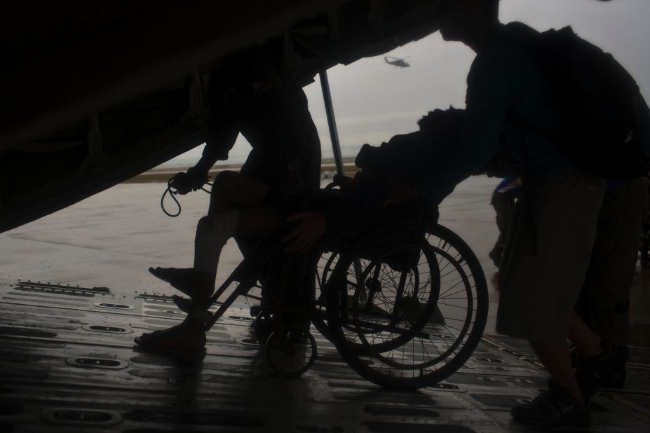 A sick elderly man is wheeled onto a Philippines military cargo aircraft as he and fellow survivors of  the typhoon are evacuated from Tacloban to Manila on November 23.