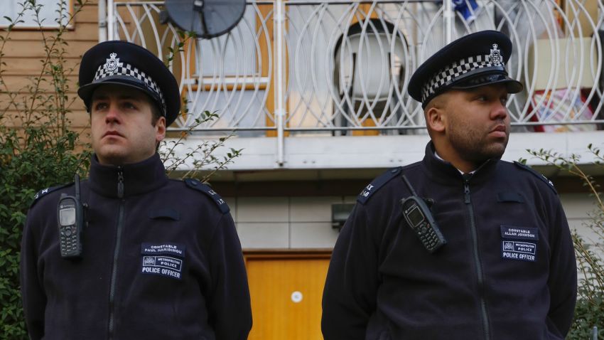 Police stand guard outside a South London block of flats that is being investigated in connection with an alleged slavery case, on November 23, 2013 in London, England. Police are conducting house-to-house inquiries in the area after three women, of British, Irish and Malaysian descent, were allegedly held captive as slaves in an apartment in Brixton for thirty years.