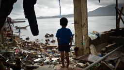 A boy peers out of a damaged structure near the shoreline on November 23, 2013 in Tacloban, Philippines.
