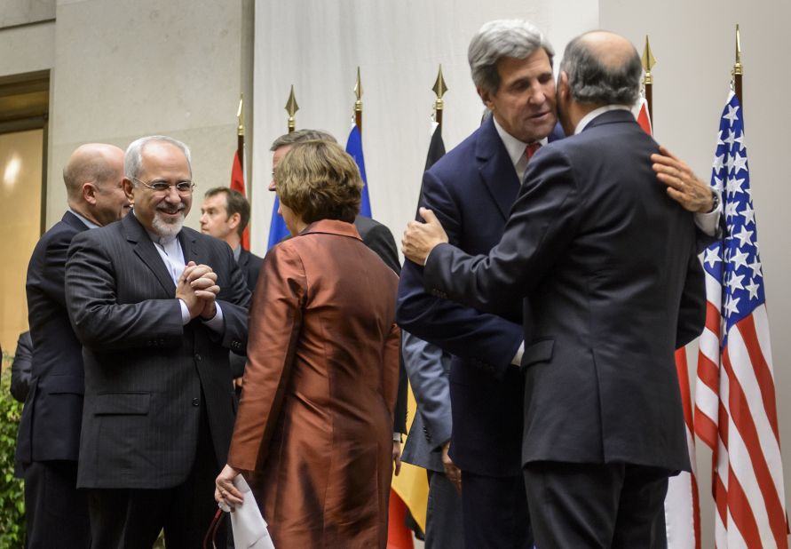 Iranian Foreign Minister Mohammad Javad Zarif talks with EU foreign policy chief Catherine Ashton as U.S. Secretary of State John Kerry embraces French Foreign Minister Laurent Fabius.