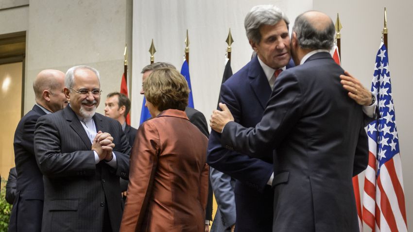 Iranian Foreign Minister Mohammad Javad Zarif talks with EU foreign policy chief Catherine Ashton as U.S. Secretary of State John Kerry embraces French Foreign Minister Laurent Fabius.