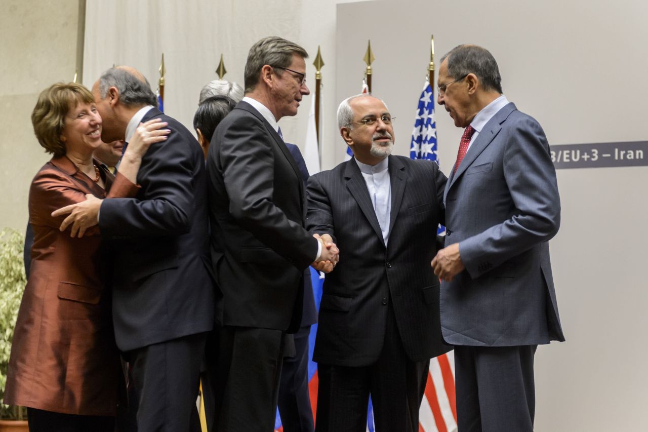 EU foreign policy chief Catherine Ashton and French Foreign Minister Laurent Fabius share a hug while German Foreign Minister Guido Westerwelle, Iranian Foreign Minister Mohammad Javad Zarif and Russian Foreign Minister Sergei Lavrov talk.