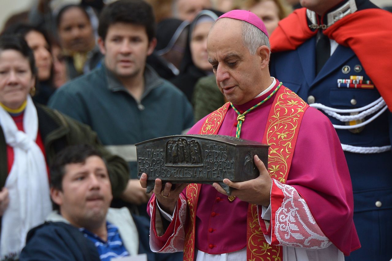 Italian archbishop Rino Fisichella holds the ashes of St Peter before a ceremony of Solemnity of Our Lord Jesus Christ the King at St Peter's square on November 24, 2013 at the Vatican.
