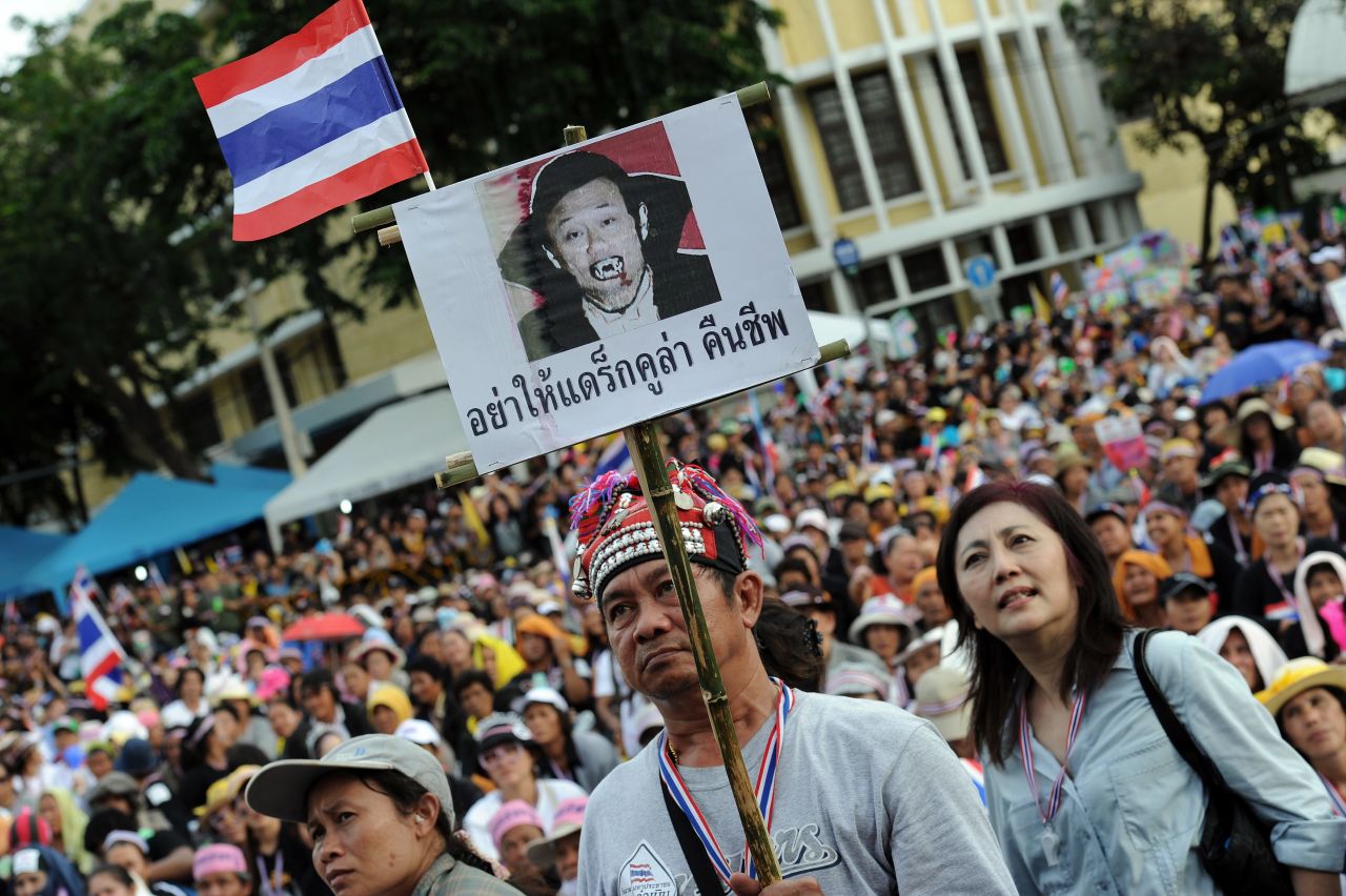 A Thai opposition protester holds up a placard mocking exiled former leader, Thaksin Shinawatra. Thaksin has a strong support base among Thailand's rural and working class, but is detested among the elite and middle classes, who accuse him of corruption.