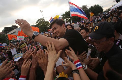 Democrat Party leader Abhisit Vejjajiva waves to anti-government protesters Sunday.