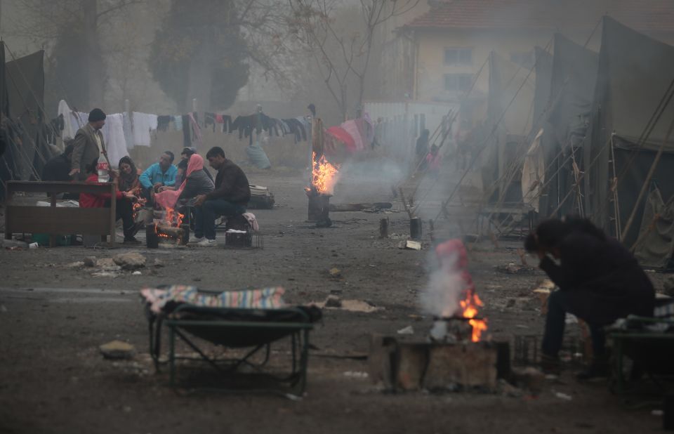 Syrian refugees warm themselves near open fires at a refugee camp in Harmanli on Thursday, November 21.