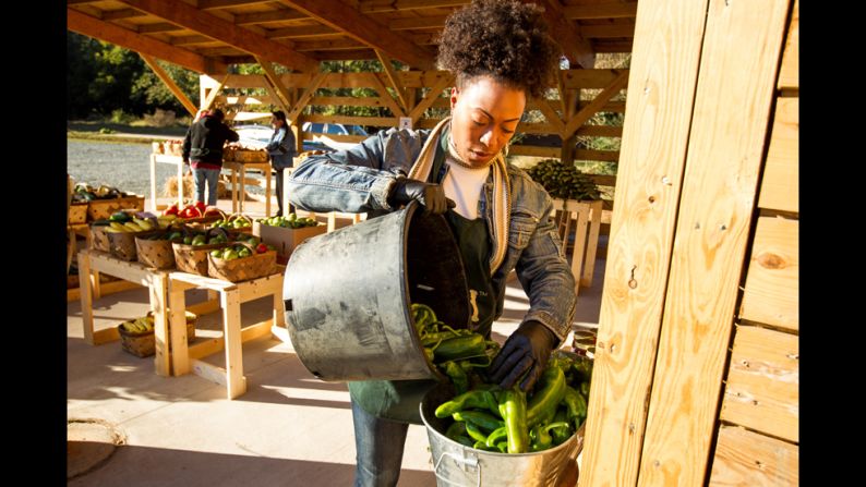 Emmons stocks produce at her market early one morning.