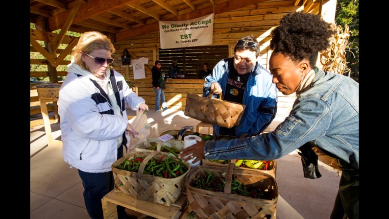 Emmons helps customers identify different types of peppers.