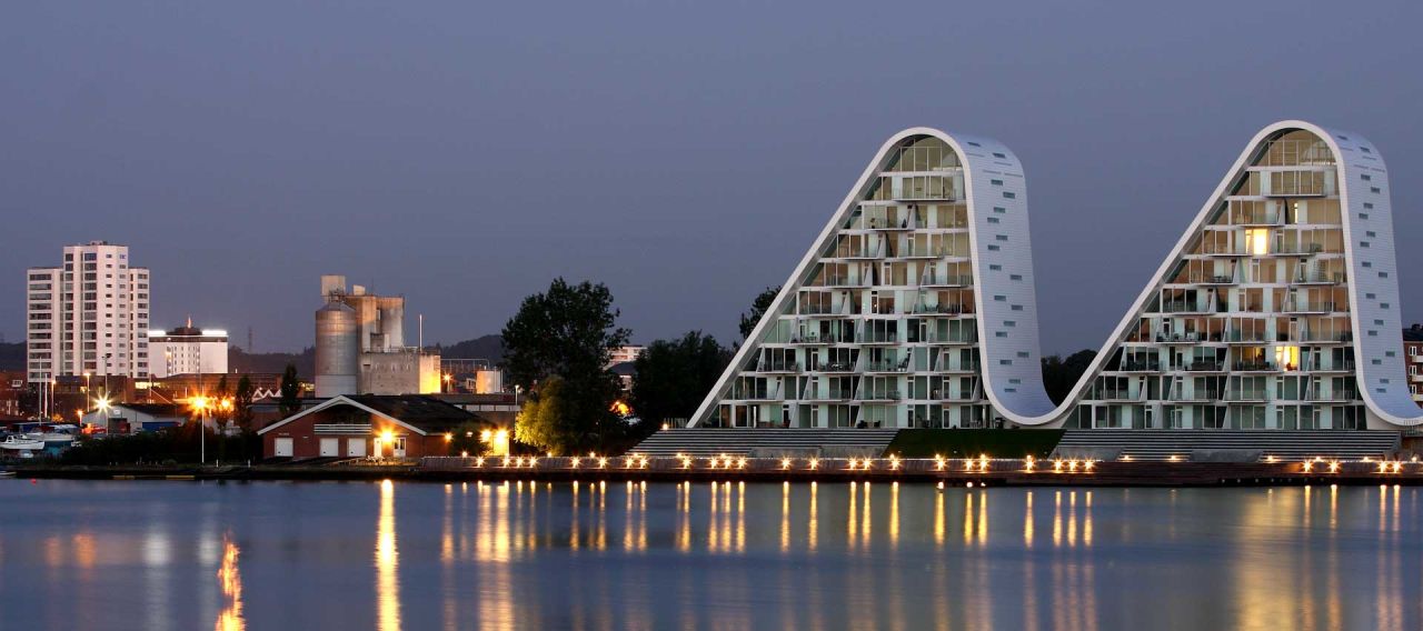 El edificio Wave en la ciudad holandesa, Vejle, refleja los suaves movimientos en la superficie durante el día y se asemeja a cimas iluminadas por la noche. 