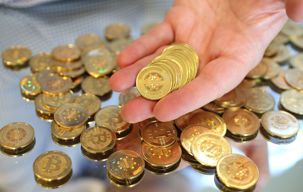 Bitcoin is an experimental digital crypto-currency unregulated by a central bank where its value -- like many real-world currencies -- is determined by how much people are willing to use it. Here, software engineer Mike Caldwell of Sandy, Utah holds physical Bitcoins he minted in his shop in April this year.