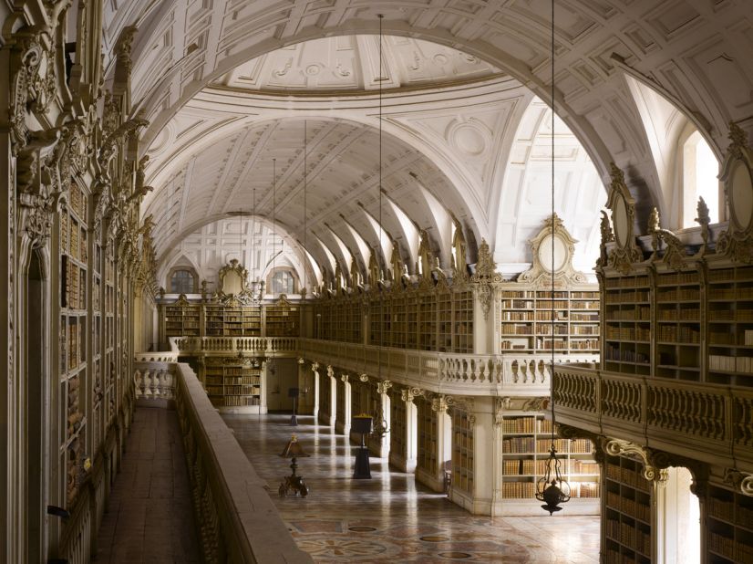 <strong>James Campbell</strong>: "The Mafra Palace Library in Mafra, Portugal is at 88 meters the longest Rococo monastic library in the world. Sadly the original designs are lost but we think it would have been covered in gold leaf with an ornate painted ceiling. However, because the construction lasted from 1717 to 1771, by the time it was completed a simplified decoration was adopted. The library also hosts a colony of bats who come out at night to feed on the insects who would otherwise eat the books."