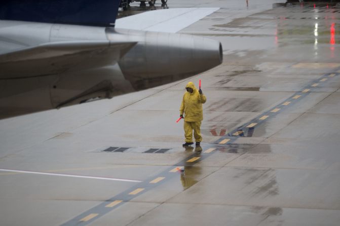 An employee signals a plane out of the gate at Ronald Reagan National Airport outside of Washington on Tuesday, November 26.