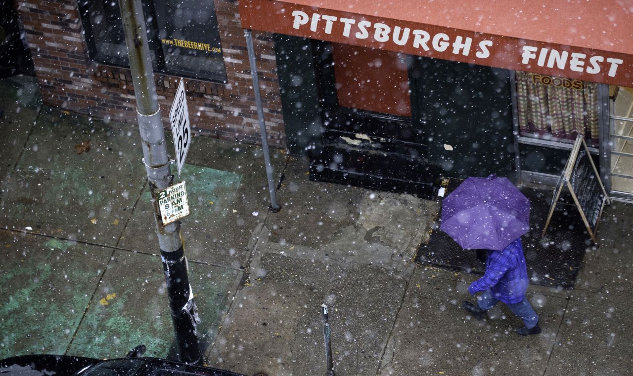 A pedestrian walks through snow showers along Penn Ave in Pittsburgh on November 26.