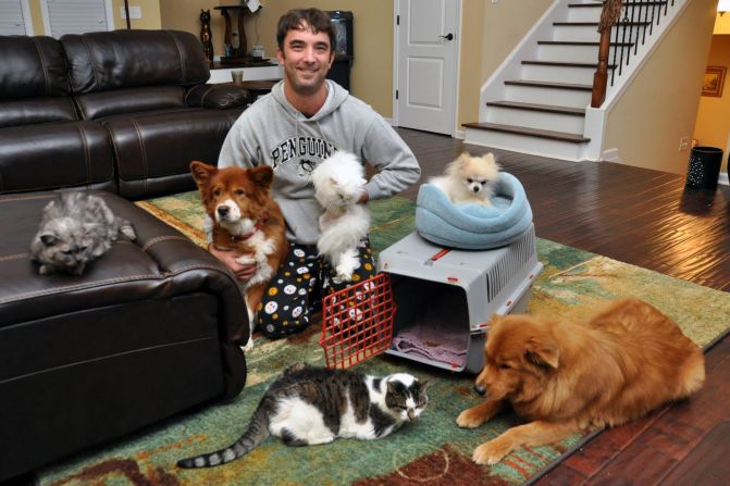 Keith Piasecki poses for his family's 2013 Christmas card newsletter with, clockwise from left, Tiki, Cayenne, Sneaky Poof, Prescious, Freddy Mercury and Joon. Squint hard and you can see Bert and Ernie, the clown fish, in the tank behind Piasecki's head. 