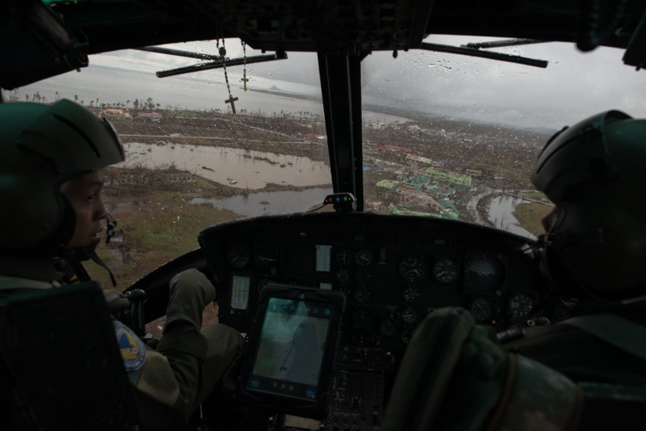 Philippines Air Force helicopter crewmen on Saturday, November 23, look at the damage to the town of Tacloban caused by Typhoon Haiyan.