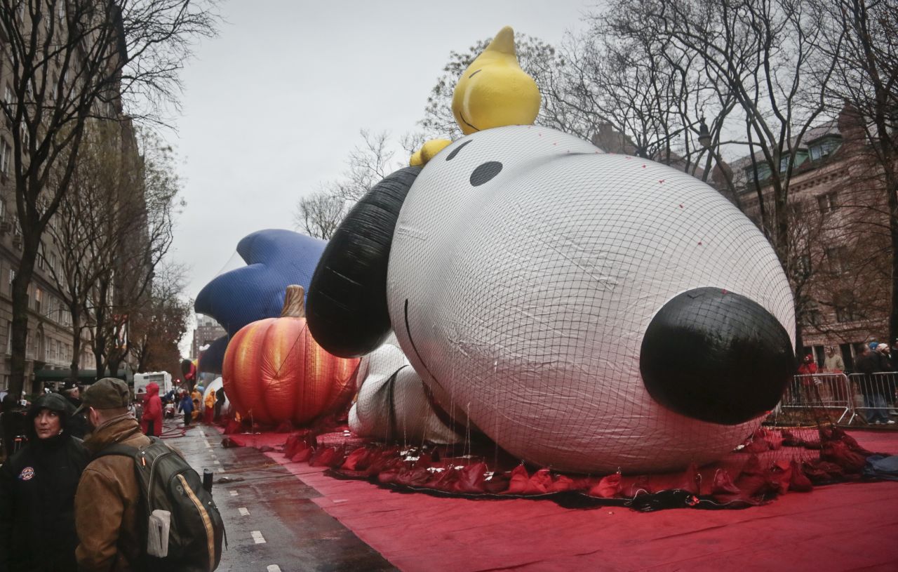 The Snoopy balloon for the Macy's Parade is partially inflated on Wednesday, November 27, in New York.  High winds threatened to keep the balloons on the ground during Thursday's Macy's Thanksgiving parade. A colossal storm system that began in California complicated Thanksgiving travel plans all the way to the Atlantic, causing many transportation delays.