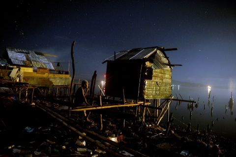 A man rests on his damaged house along the shore in Tacloban on Monday, November 25.