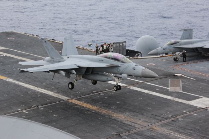 An FA-18 fighter aircraft sweeps in to land on the USS George Washington.