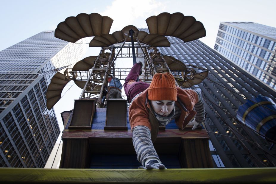 A performer slides down a pole on the Cirque du Soleil float.