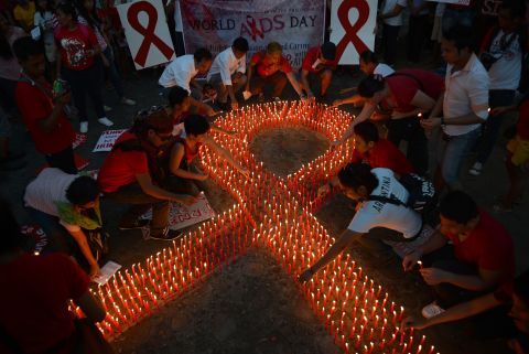 AIDS activists light a group of candles placed in the shape of a red ribbon during an event marking World AIDS Day in Manila on December 1, 2012.