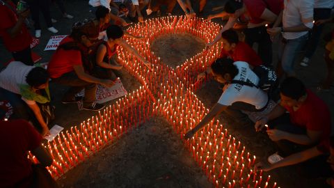 AIDS activists light a group of candles placed in the shape of a red ribbon during an event marking World AIDS Day.