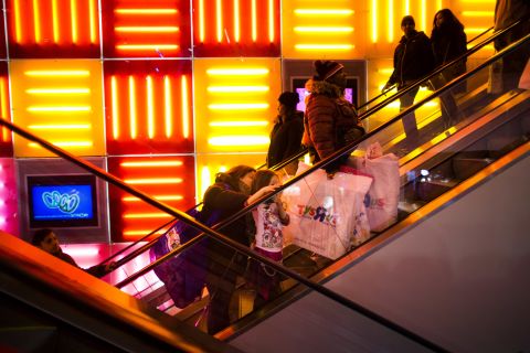 Shoppers ride the escalators at the Times Square Toys R Us on Thanksgiving Day.