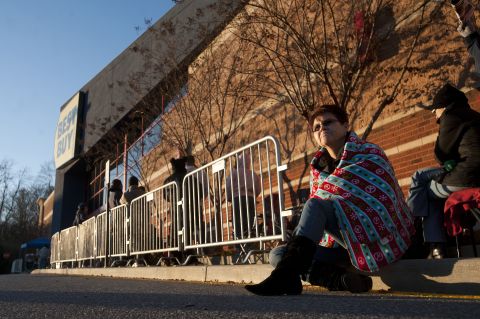 Karen Hudson sits on the curb at a Best Buy in Lynchburg, Virginia, as she waits for employees to hand out vouchers for early Black Friday deals November 28.