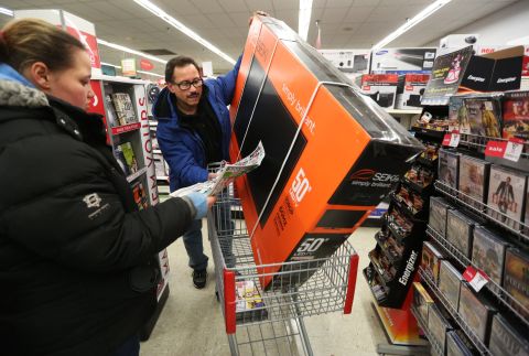 Luis Torres and his daughter Stephanie search for more deals after picking up a 50-inch television at a Chicago Kmart on November 28.