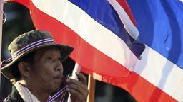 An anti-government protester blows a whistle in front of Thai National flags during rally at the Democracy Monument in Bangkok, Thailand, Friday, Nov. 29, 2013. Thailand's prime minister begged protesters Thursday to call off their sustained anti-government demonstrations and negotiate an end to the nation's latest crisis.(AP Photo/Sakchai Lalit)